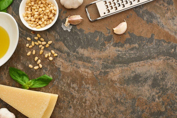 top view of pesto sauce ingredients and grater on stone surface