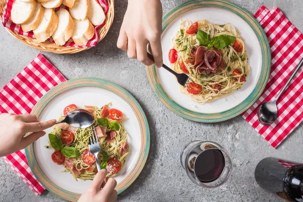 Cropped View Women Eating Pappardelle Tomatoes Basil Prosciutto Baguette Red — Stock Photo, Image