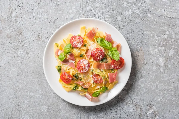 Vrchní Pohled Vařené Pappardelle Rajčaty Pesto Omáčkou Prosciutto Šedém Povrchu — Stock fotografie