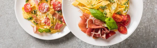 調理されたパパルデッレの選択的な焦点トマト バジルとプロシュットグレーの表面上のプレート上 パノラマショット — ストック写真
