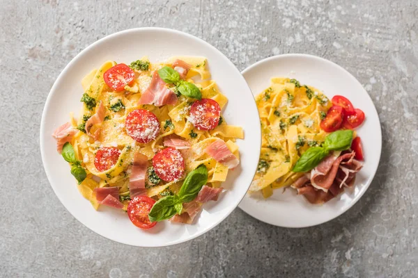 Selective Focus Cooked Pappardelle Tomatoes Basil Prosciutto Plates Grey Surface — Stock Photo, Image