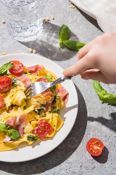 Częściowy Widok Kobiety Jedzącej Smaczne Pappardelle Pomidorami Pesto Prosciutto Pobliżu — Zdjęcie stockowe