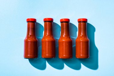 Top view of ketchup in bottles on blue background clipart