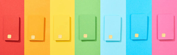 top view of multicolored empty credit cards on rainbow background, panoramic shot