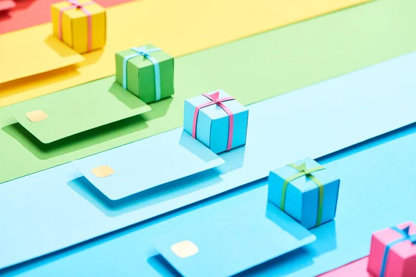 彩虹背景下五颜六色的空信用卡和礼品盒 — 图库照片