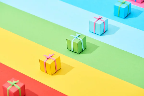 multicolored gift boxes on rainbow background