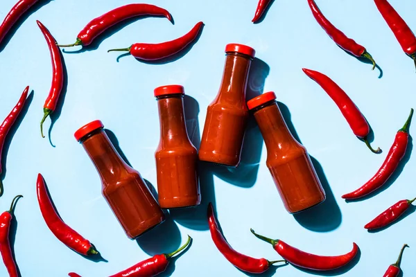 Top View Bottles Homemade Chili Sauce Chili Peppers Blue Background — Stock Photo, Image