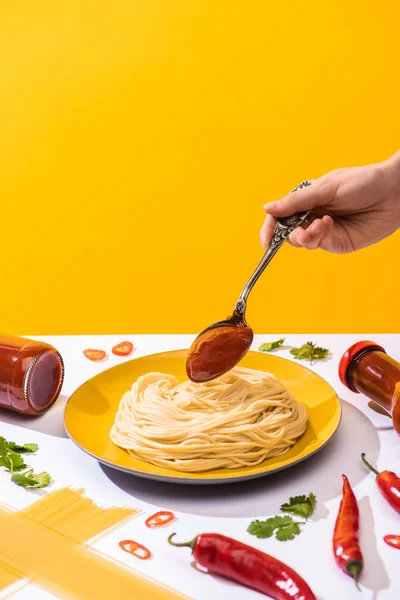 Vista Cortada Mulher Adicionando Ketchup Espaguete Superfície Branca Isolada Amarelo — Fotografia de Stock