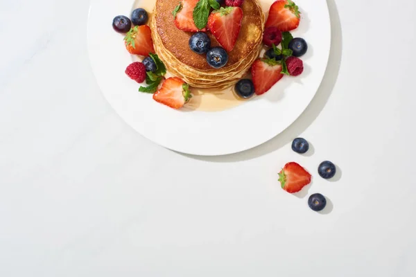 Vista Superior Deliciosos Panqueques Con Miel Arándanos Fresas Superficie Blanca —  Fotos de Stock