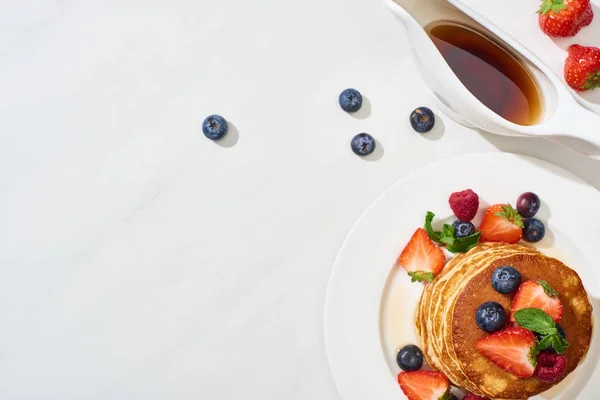 Bovenaanzicht Van Heerlijke Pannenkoeken Met Ahornsiroop Bosbessen Aardbeien Bord Marmeren — Stockfoto