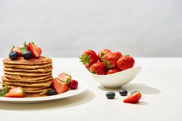 Deliciosas Panquecas Com Mirtilos Morangos Placa Superfície Branca Isolada Cinza — Fotografia de Stock