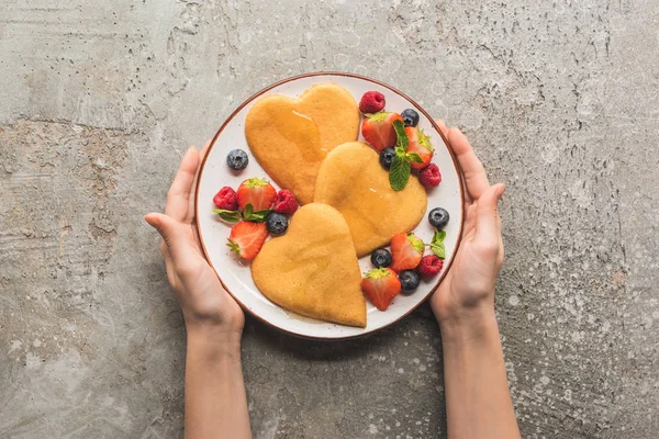 Cropped View Woman Holding Plate Heart Shaped Pancakes Berries Grey — Stock Photo, Image