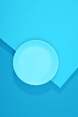 Renkli mavi yüzeydeki boş tabağın üst görünümü