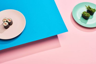 Deniz yosunlu taze nigiri ve mavi, pembe arka planlı ton balıklı maki