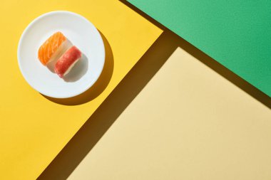 Yeşil ve sarı yüzey üzerinde somon ve ton balıklı taze nigiri manzarası