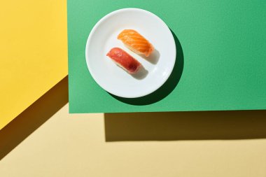 Yeşil ve sarı yüzey üzerinde somon ve ton balıklı taze nigiri manzarası