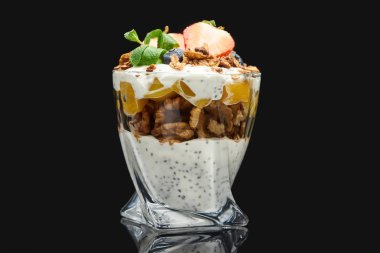 taze granola konserve şeftali, böğürtlen, ceviz ve chia tohumları siyah üzerine izole