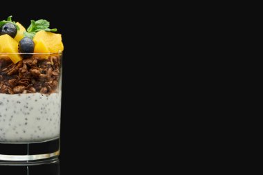 taze granola konserve şeftali, yaban mersini ve chia tohumları siyah üzerine izole