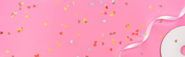 top view of valentines confetti, empty compact disk, ribbon on pink background, panoramic shot clipart