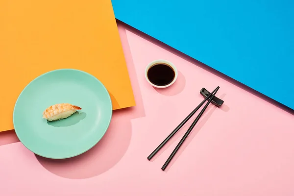 新鲜的黑鬼 虾在酱油附近 筷子在蓝色 粉红色 橙色表面 — 图库照片