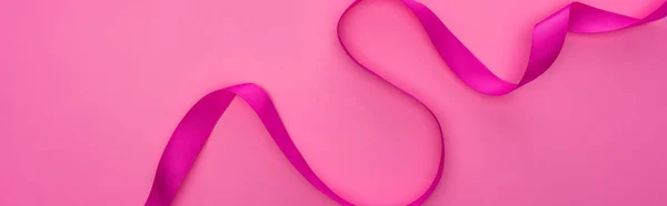 ピンク色に孤立した絹の曲線状のリボンの上からの眺め — ストック写真