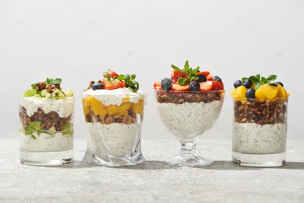 delicious granola in glasses with fruits and berries isolated on white