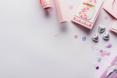 Sevgililer Günü dekorasyonu, hediyeler, kalpler ve beyaz arka planda ambalaj kağıtlarının üst görüntüsü