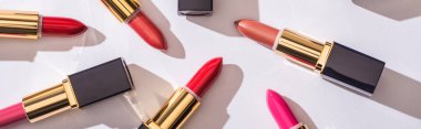 top view of assorted lipsticks in luxury tubes on white background, panoramic shot clipart
