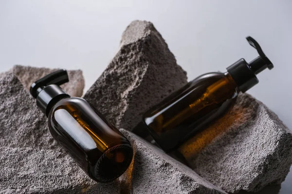 Spender Kosmetikflaschen Auf Felsen Isoliert Auf Grau — Stockfoto