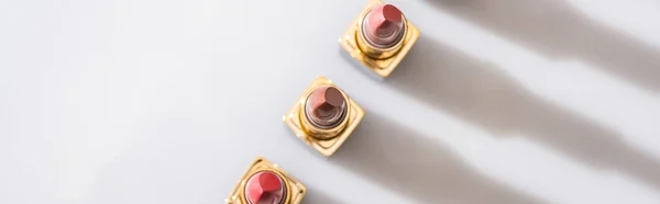 Top View Assorted Lipsticks Luxury Tubes Line White Background Panoramic — Stock Photo, Image