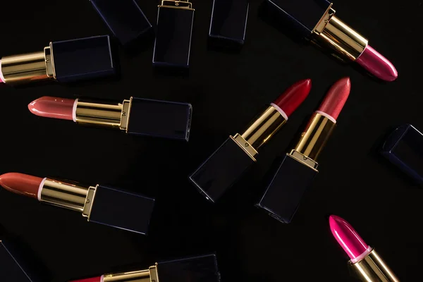 Draufsicht Auf Verschiedene Lippenstifte Luxusröhrchen Vereinzelt Auf Schwarz Verstreut — Stockfoto