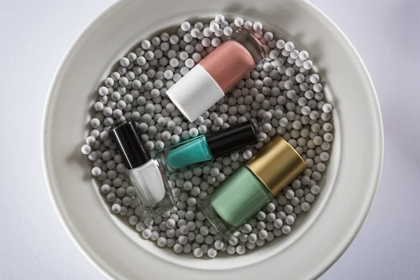 Top View Assorted Nail Polish Bottles Plate Grey Decorative Beads — Stock Photo, Image