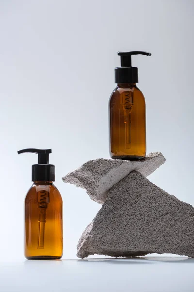 Spender Kosmetikflaschen Mit Steinen Auf Weißem Hintergrund Mit Gegenlicht — Stockfoto