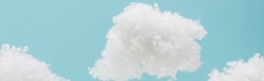 white fluffy clouds made of cotton wool isolated on blue background, panoramic shot clipart