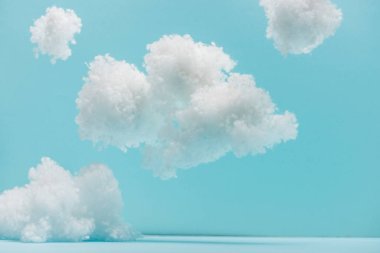white fluffy clouds made of cotton wool isolated on blue clipart