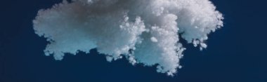 Pamuktan yapılmış beyaz tüylü bulut koyu mavi, panoramik çekimde izole edilmiş.