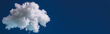 white fluffy cloud made of cotton wool isolated on dark blue, panoramic shot clipart