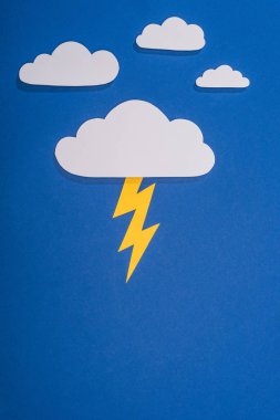 top view of white paper cut clouds with lighting on blue background clipart