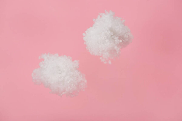 белые пушистые облака из ваты, изолированные на розовом
