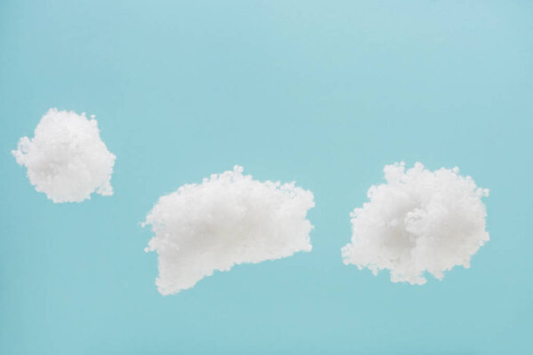 white fluffy clouds made of cotton wool isolated on blue background