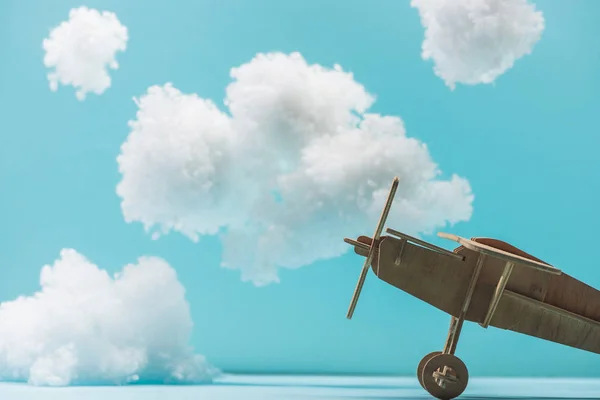 Beyaz Tüylü Bulutların Arasında Mavi Yünden Yapılmış Ahşap Oyuncak Uçak — Stok fotoğraf