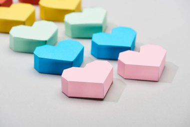 Gri arkaplanda dekoratif renkli kağıt kalpler