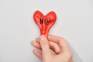 Gri arka planda harfi olmayan kırmızı balon tutan kadın manzarası, kırpık manzara.