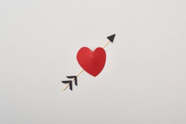 Kırmızının üst görünümü kalp şeklinde ve ok gri üzerine izole edilmiş