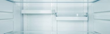 Panoramic shot of clean shelves of refrigerator clipart