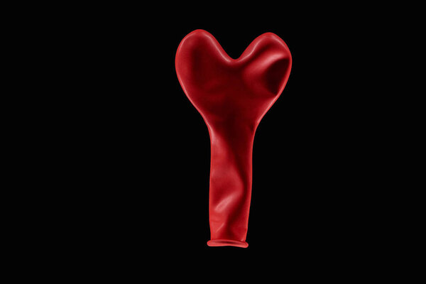 Top view of red balloon in heart shape isolated on black 