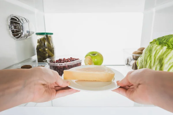 白で隔離された果物や漬物で冷蔵庫からチーズを取る女性の作物ビュー — ストック写真