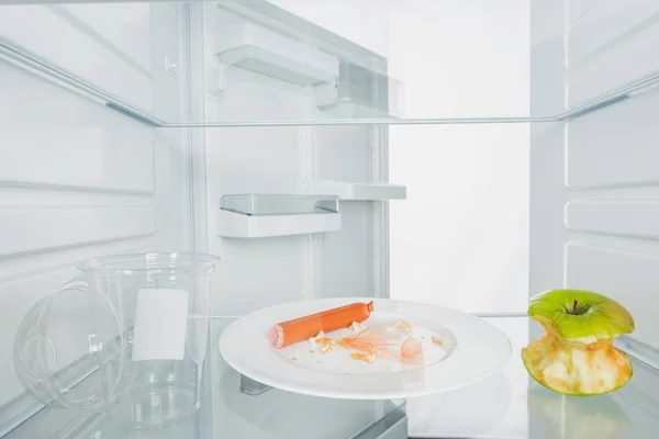 Тарелка Объедками Кусатые Яблоки Пластиковые Чашки Холодильнике Открытой Дверью Изолированы — стоковое фото