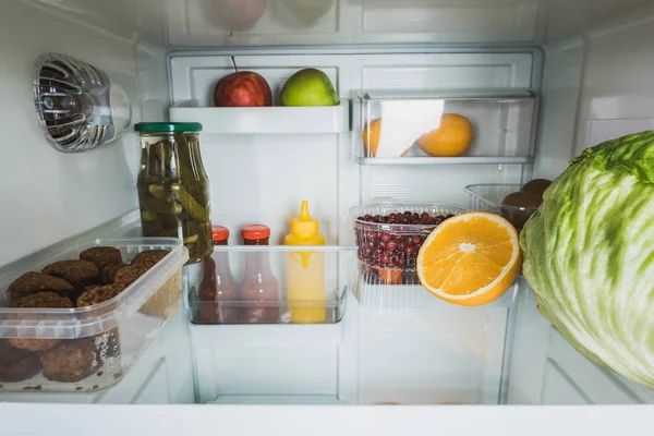 Tasty cutlets with fresh cabbage and fruits in refrigerator — Stock Image Tasty Cutlets Fresh Cabbage Fruits Refrigerator Royalty Free Stock Photos