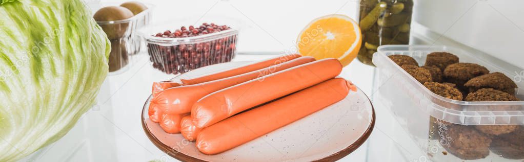 Panoramic shot of sausages, cutlets with cabbage and fruits in refrigerator isolated on white — Stock Image Panoramic Shot Sausages Cutlets Cabbage Fruits Refrigerator Isolated White Stock Image
